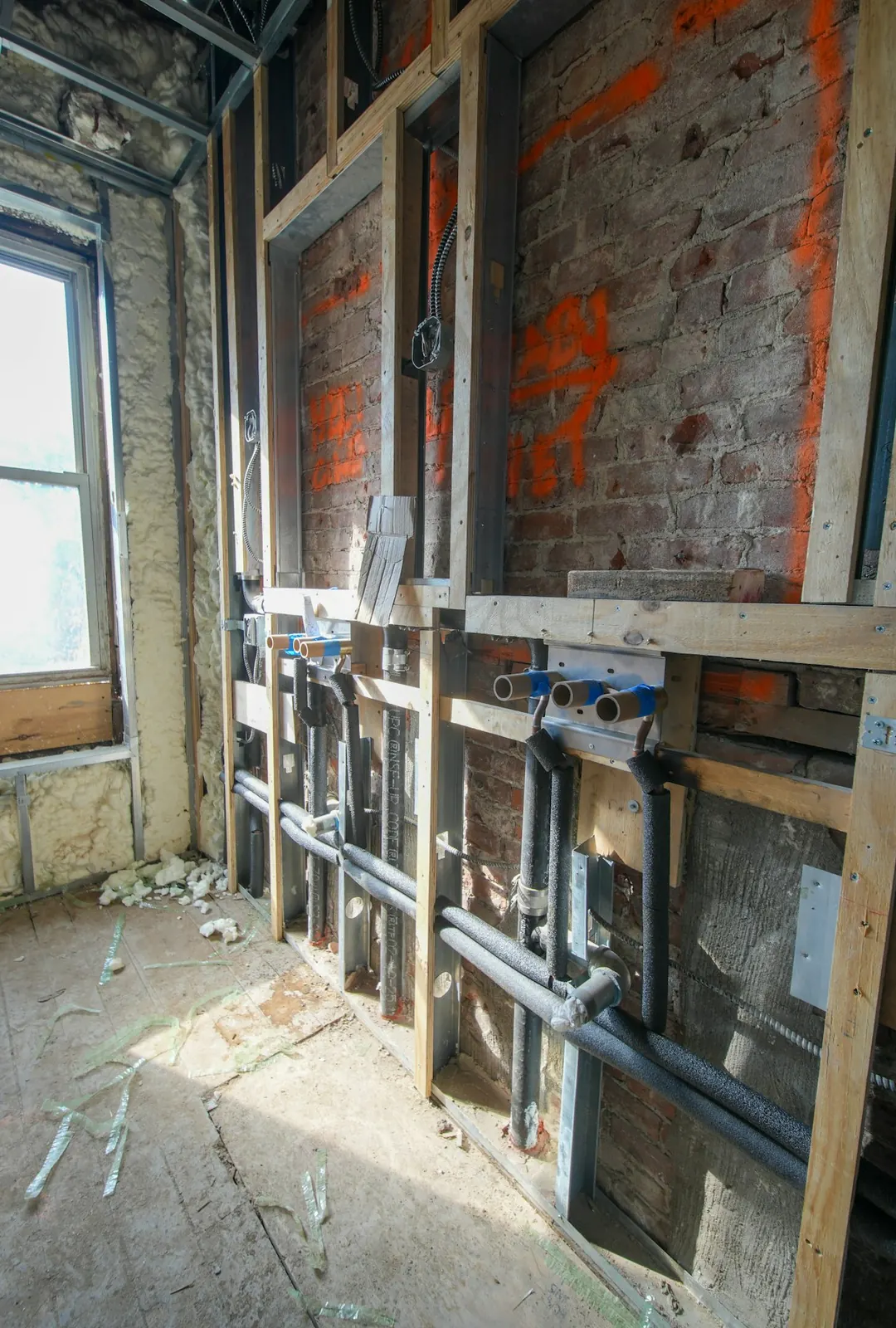 An open room before drywall, with wiring run along the block walls