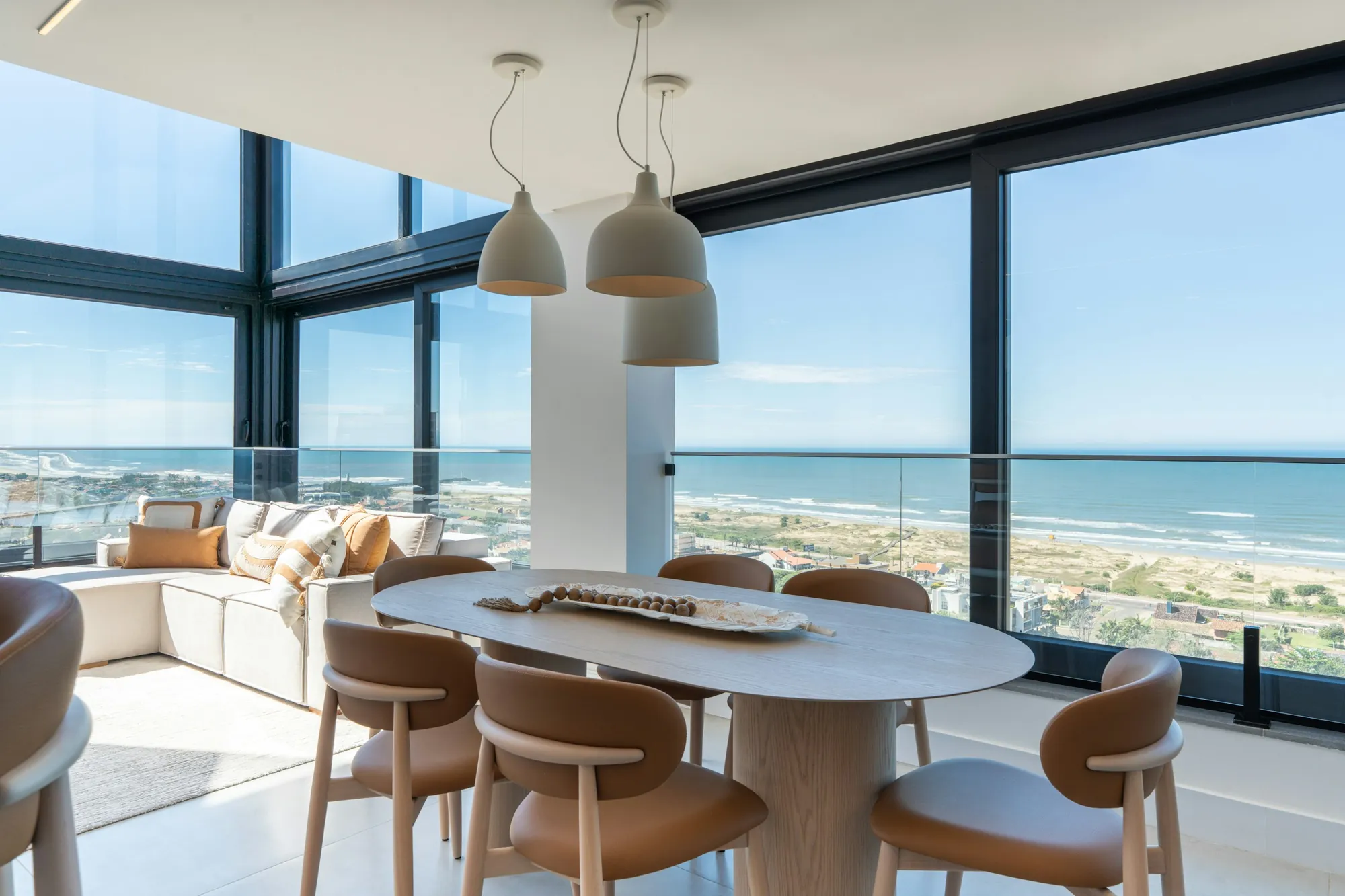 A dining room with floor-to-ceiling glass to the ocean