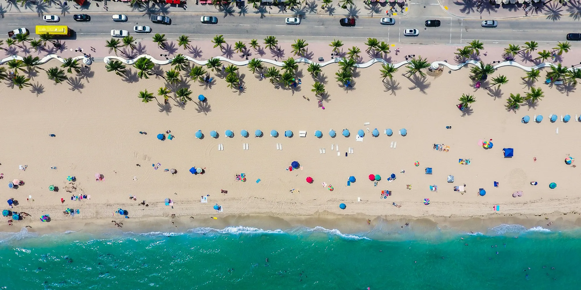 Fort Lauderdale Beach from above, with palms and umbrellas along A1A
