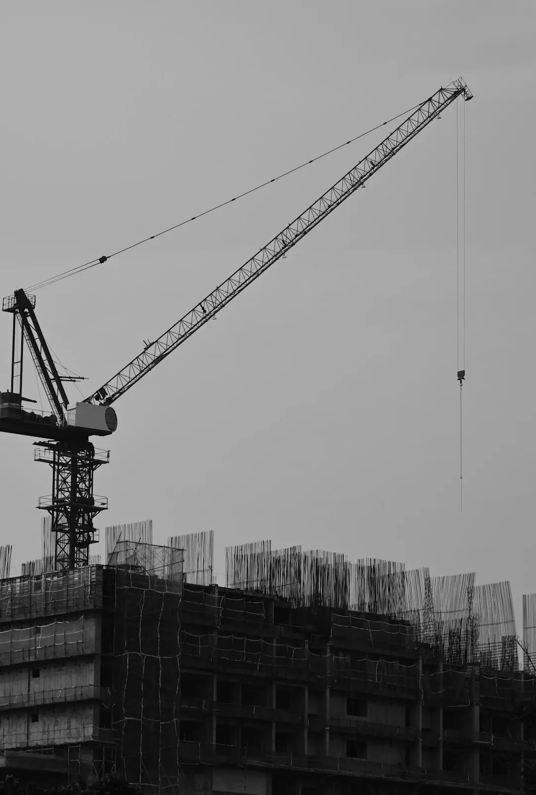 A tower crane above a building as it starts to rise