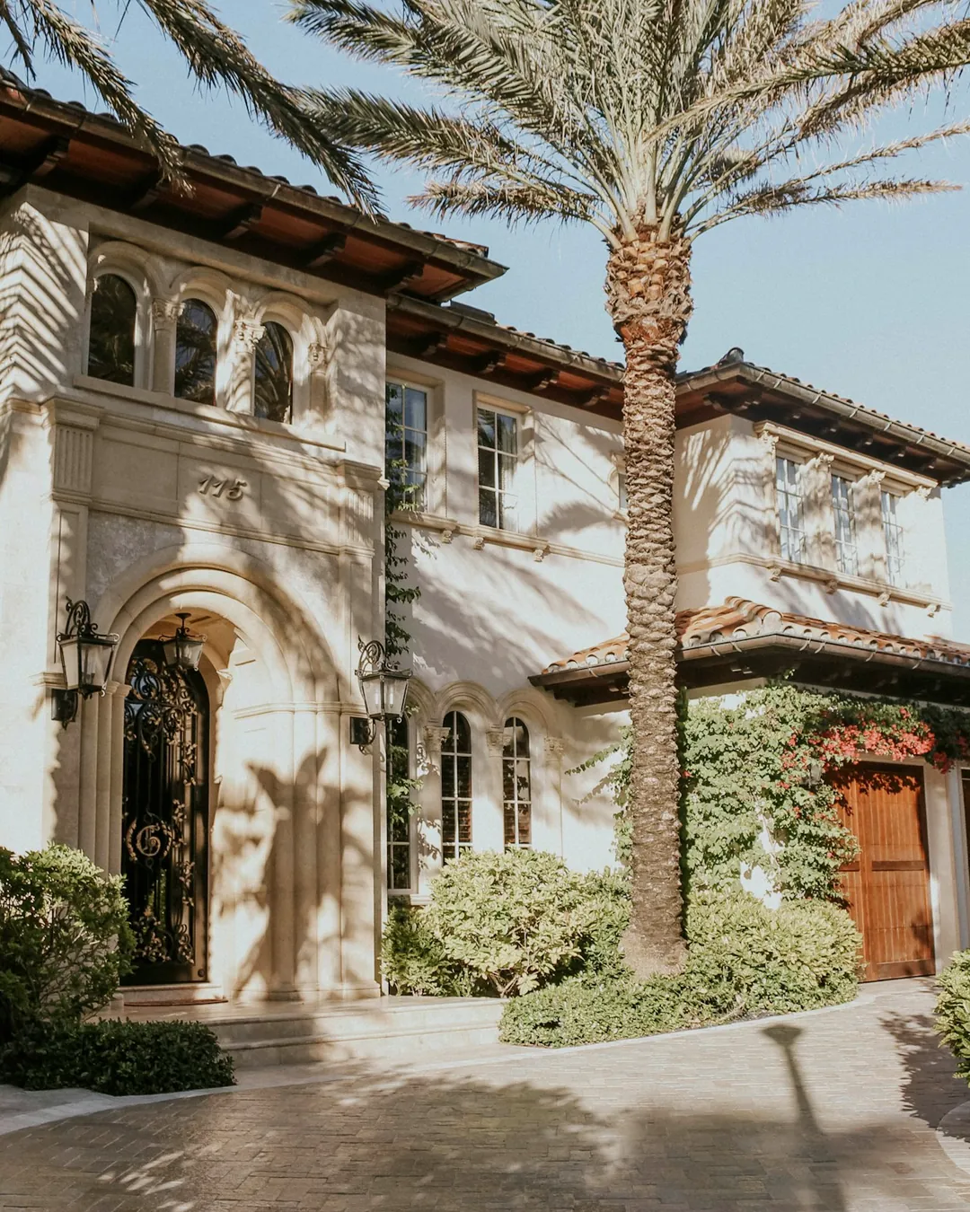 A Mediterranean-style home behind tall palms